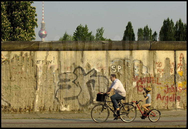 Berlin : Alors que la reconstruction des territoires de l’ancien no man’s land sont quasiment achevés, il reste encore quelques vestiges du mur qui séparait l’Est et l’Ouest, comme ici, sur Bernauer strasse, dans le nord de la ville. En arrière plan, la tour de Berlin, décorée pour l’occasion en ballon de football.