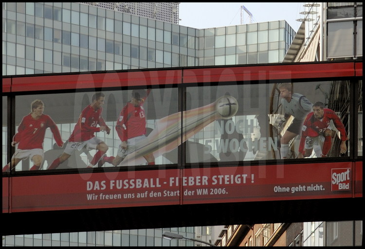 Gelsenkirschen : Dans le centre ville, une affiche de football le long d’un corridor aérien entre deux bâtiments de bureaux.