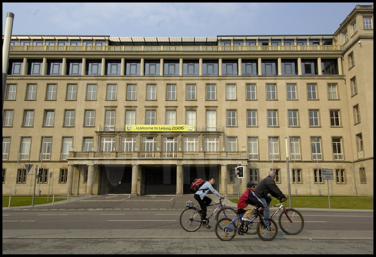 Leipzig : Cyclistes devant l’entrée principale de l’ancien stade construit en 1956 qui est réutilisée pour la nouvelle enceinte.