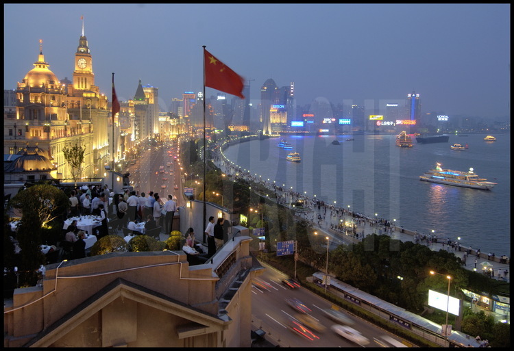 Dans le centre ville de Shanghai, les quais du Bund et ses péniches navigants sur la Huang Pu river en 2005. Au premier plan, la terrasse d'un des nouveaux restaurants branchés de la ville.