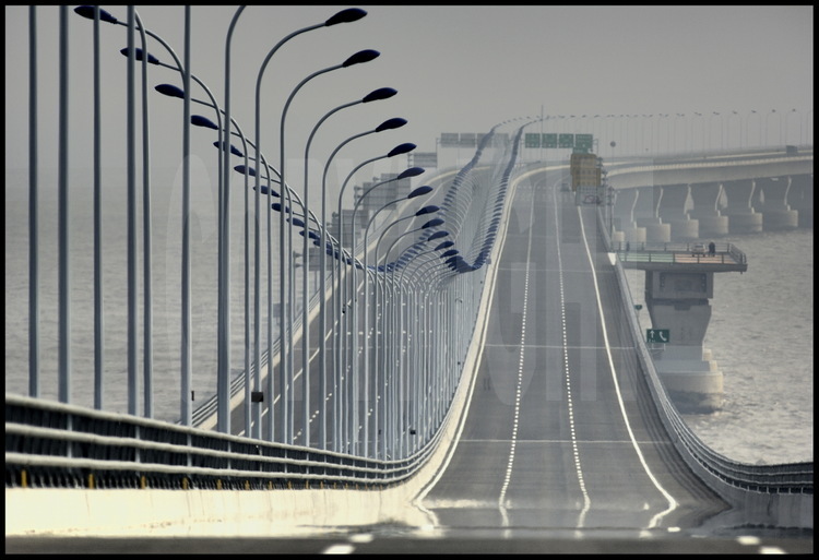 Novembre 2005. Sur le tablier du pont de Donghai un mois avant son ouverture officielle, à hauteur de l’élévation 2, point  kilométrique 10. A droite, une zone de dépose d'urgence pour hélicoptère. En arrière plan, le premier virage, distant de cinq kilomètres.