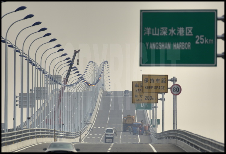 Novembre 2005. Sur le tablier du pont de Donghai un mois avant son ouverture officielle, au point kilométrique 7. Derniers travaux de finition sur la signalisation et l'éclairage.