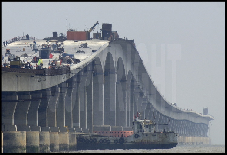 Juin 2005. Derniers travaux sur le tablier du pont de Donghai -avant la pose, de juillet à octobre, de 100000 tonnes d’asphalte- à la hauteur de l’élévation 4, qui permet le passage des navires de 1000 tonnes maximum (kilomètre 24). En dehors du pont suspendu central, le pont possède trois autres élévations, au point kilométrique 5, 10 et 24, pour le passage des bateaux de moyen tonnage. Le pont est posé sur 670 séries de pylônes, tandis que l’espace entre chaque pilier est de cinquante mètres.