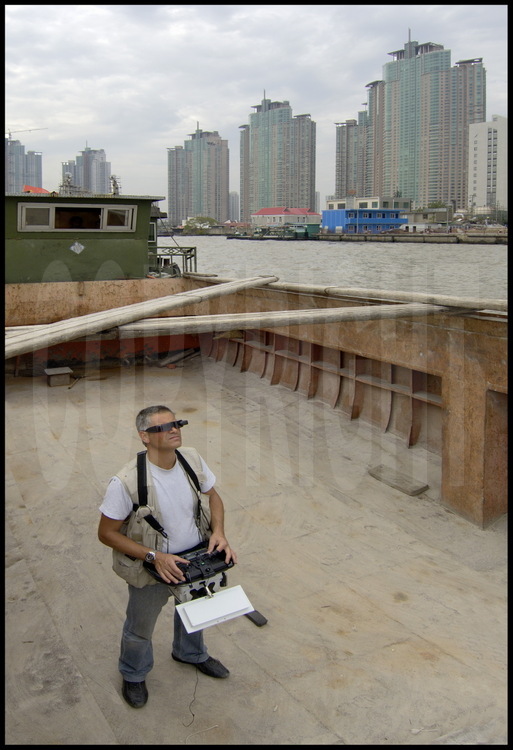Les photos aériennes de ce reportage ont été réalisées à l’aide d’un ballon radio-commandé depuis la mer ou le fleuve, comme sur cette péniche navigant sur la Huang Pu river. En arrière plan, des tours d’habitation de la ville de Pudong.