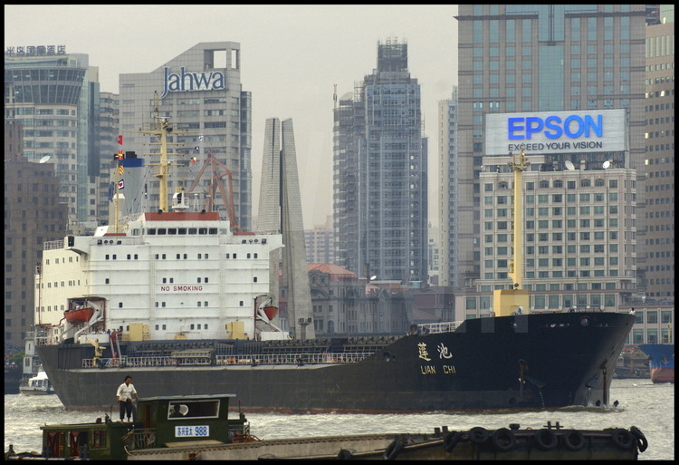 Au beau milieu du centre ville de Shanghai, un tanker pétrolier navigue sur la Huang Pu river aussi tranquillement qu'une simple péniche. En arrière plan, des tours de bureaux de la  ville de Puxi (qui signifie « à l’ouest du Pu ») et le « Mémorial aux Héros » de la ville.