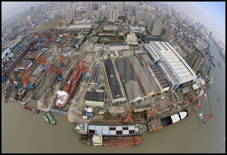 Situé sur la rive gauche de la Huang Pu river, au sud du centre ville, le chantier naval de Jiang Nan, plus ancien port de Chine construit par les Britanniques dans les années 1850. Il  sera entièrement détruit en 2006 et 2007 pour faire place aux installations de l’exposition universelle de 2010. En arrière plan, des tours d’habitations de Puxi (qui signifie « à l’ouest du Pu »), la partie ouest et ancienne de Shanghai.