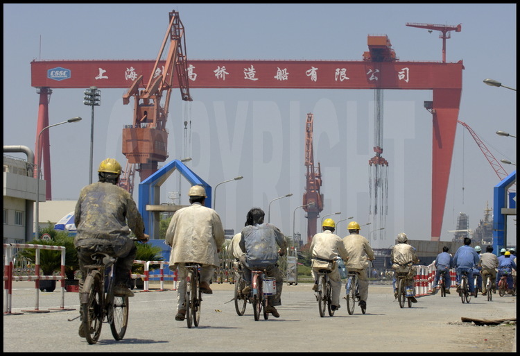 Ouvriers shanghaiens à l’entrée du chantier naval de Waigaoqiao, le plus grand de Chine, situé sur la rive droite de l’estuaire du Yang Tse Kiang.