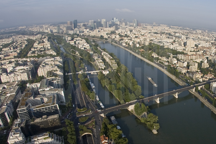 Vue de la banlieue ouest de Paris avec, au premier plan (de g. à d.), la ville de Levallois-Perret, l'île de la Jatte, la Seine et la ville de Courbevoie. En arrière plan (de g. à d.), la ville de Neuilly et les tours de la Défense. Altitude 150 mètres.