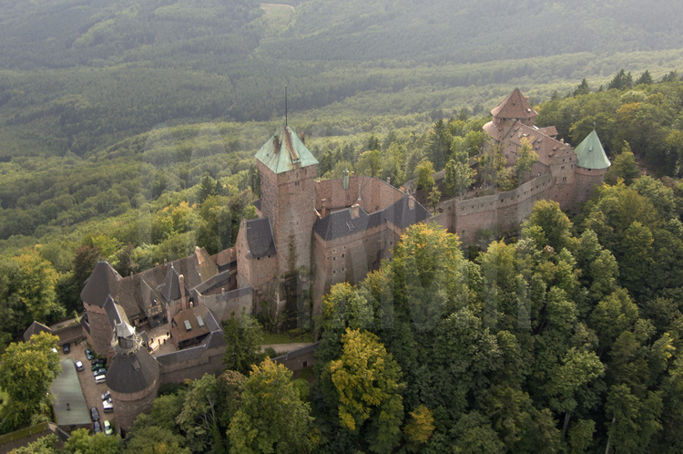 Vue aérienne du de la façade nord du château du Haut-Kœnigsbourg. Dominant la plaine d'Alsace à une altitude de 755 m, le château du Haut-Kœnigsbourg est l'un des sites touristiques les plus fréquentés en France, avec près de 500 000 visiteurs par an. Appartenant à l'État français depuis 1919, le site fut transféré par l'État au Conseil général du Bas-Rhin en janvier 2007 (transfert qui fut le premier bien patrimonial transféré par l'État parmi une liste de 176).