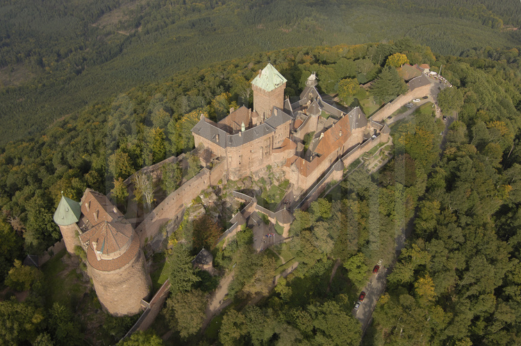 Vue aérienne du de la façade sud du château du Haut-Kœnigsbourg. Dominant la plaine d'Alsace à une altitude de 755 m, le château du Haut-Kœnigsbourg est l'un des sites touristiques les plus fréquentés en France, avec près de 500 000 visiteurs par an. Appartenant à l'État français depuis 1919, le site fut transféré par l'État au Conseil général du Bas-Rhin en janvier 2007 (transfert qui fut le premier bien patrimonial transféré par l'État parmi une liste de 176).