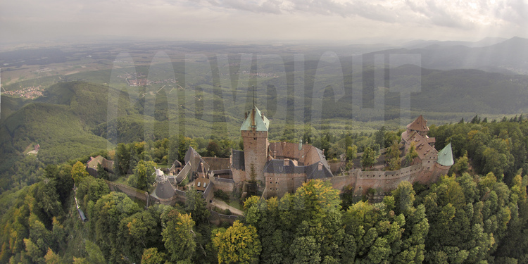 Vue aérienne du de la façade nord du château du Haut-Kœnigsbourg. Dominant la plaine d'Alsace à une altitude de 755 m, le château du Haut-Kœnigsbourg est l'un des sites touristiques les plus fréquentés en France, avec près de 500 000 visiteurs par an. Appartenant à l'État français depuis 1919, le site fut transféré par l'État au Conseil général du Bas-Rhin en janvier 2007 (transfert qui fut le premier bien patrimonial transféré par l'État parmi une liste de 176).