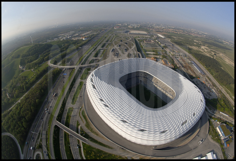 Munich : Alors que le  stade olympique avait en son temps été salué pour son audace architecturale, nul doute que Le Munchner stadion, d’une capacité de  66000 places couvertes, va lui aussi faire parlé de lui avec sa structure de membrane à coussin d’air, réellement innovante, qui le font ressembler à un gigantesque cocon flottant. En arrière plan, la ville de Munich.