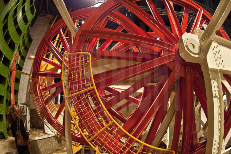 Au sous-sol du pilier est de la Tour Eiffel, la machinerie d'ascenseur de 1889, toujours en fonctionnement. En rouge, deux des gigantesques poulies du système (voir image n° 106).