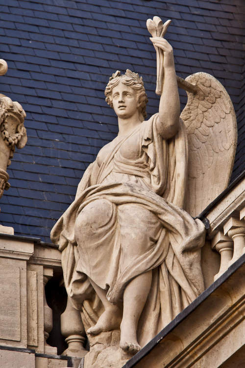 Derrière cette statue allégorique juchée sur la balustrade nord de la cour de Marbre, la toiture en ardoise, un matériau considéré comme plus chic que la tuile.