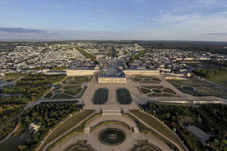 Vue d'ensemble du Château, des jardins et de la ville de Versailles depuis l'ouest. Au premier plan, le bassin de Latone, les Parterres d’eau avec les Parterres d'eau et le Tapis Vert.