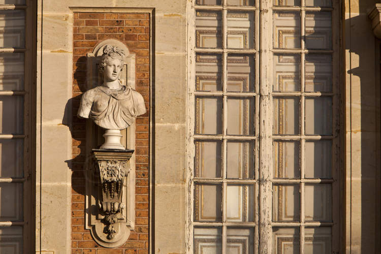 Un des quatre-vingt quatre bustes à l’antique des cour Royale et cour de Marbre. Buste d'empereur romain, dans l'aile du Midi. Cette façade met en valeur un mur de brique, un matériau très présent sur les bâtiments tournées vers la ville.