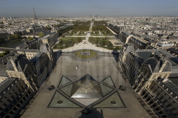 Cour principale du Musée avec l'aile Denon à g., la Pyramide au centre et l'aile Richelieu à d.. En arrière plan (de g. à d.), la Seine et le pont du Caroussel, le dôme des Invalides, la Tour Eiffel, l'Arc du Carroussel, le jardin des Tuileries, la perspective des Champs Elysées et de la Défense. Altitude 40 mètres.