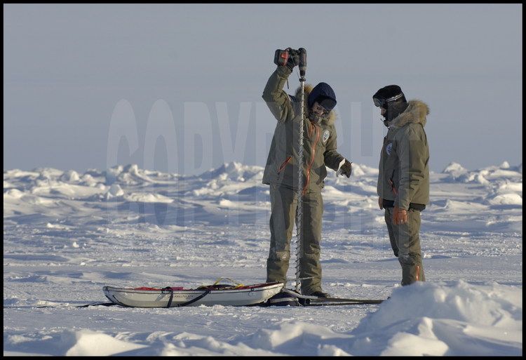 Afin de confirmer les données recueillies par le trio EM-Bird - Topographie terrestre - ROV, Christian Haas et Samuel Audrain effectue quelques mesures d'épaisseur de neige et de glace sur la zone délimitée par les scientifiques.