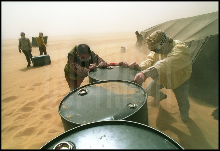 Le campement durant une sévère tempête de sable, fréquente pendant cette saison. Des futs sont disposés pour éviter que le sable ne s'engouffre trop rapidement dans les tentes.