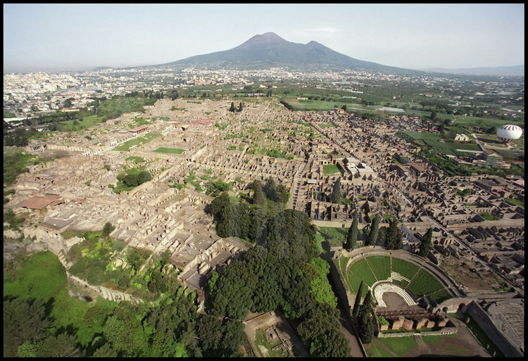 Vue aérienne de Pompéi depuis le Sud. Au premier plan à droite, le théâtre et l'odéon. En arrière plan, le Vésuve.