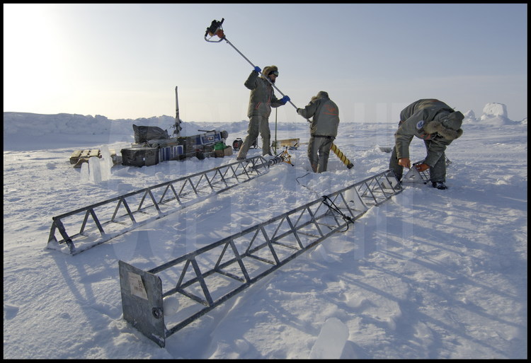 Pour permettre au ROV d'envoyer les données de topographie sous-marine vers la surface, un capteur fixé au bout d'un pylône métallique est immergé  au bord du trou creusé dans la glace.