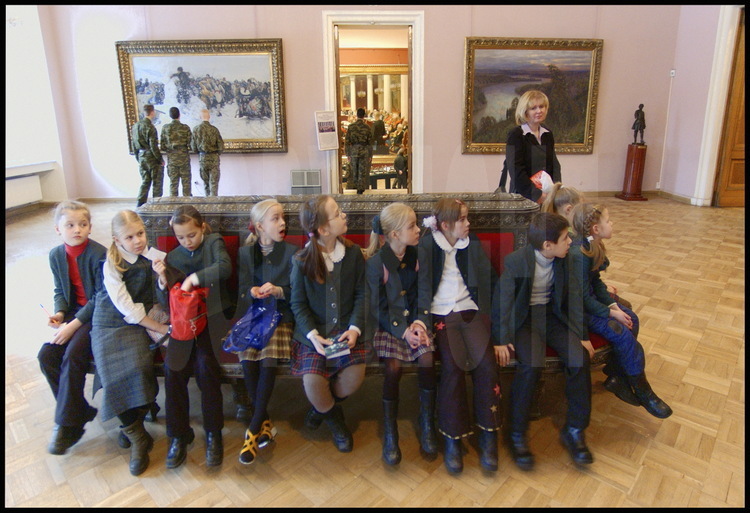 Musée Russe. Une classe d'école de fillettes russes avec leur maîtresse visitent les salles de peintures russes du XIXème siècle. En arrière plan, un groupe de jeunes militaires russes.