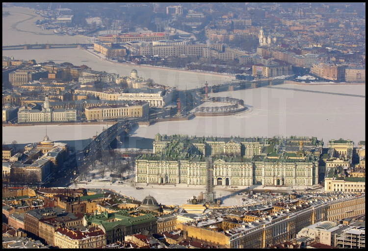 Aerial view of the Hermitage Museum and of the historical city center.  
In the foreground, the general army headquarters, Palace Place, and the 
Alexander Column.  In the middle from left to right, the Admiralty, the 
Dvortsovy Bridge, the Hermitage and the Winter Palace.  Behind from left to 
right, the Strelka (the tip) of Vassilievki Island with the Kounskamera, the 
Academy of Sciences, the Marine Museum, and the Rostral Columns.  In the 
background, Petrograd, the city's first neighborhood, founded in 1703.
