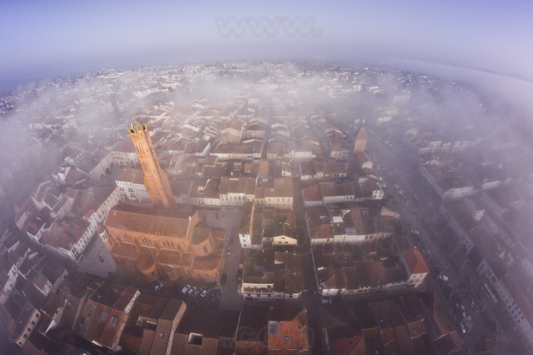 Villeneuve sur Lot : the city center emerges from the morning mist. In the left foreground, Sainte Catherine church. In the background on the right, the tower of Paris.