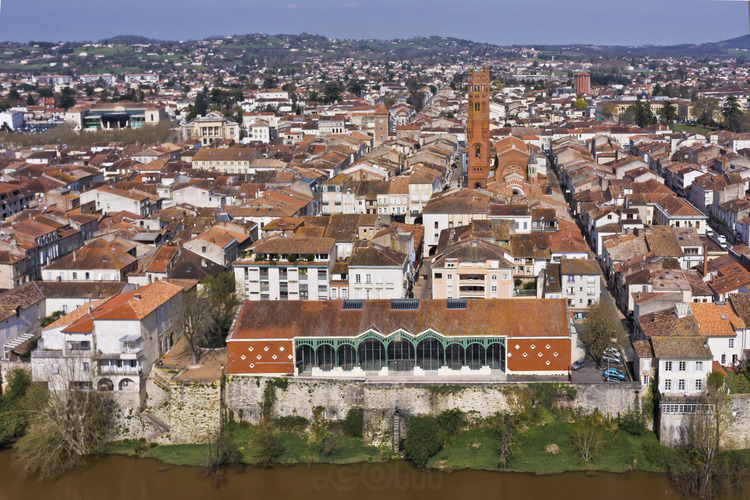 Villeneuve sur Lot : the city center from the left bank. Altitude 80 m. In the foreground, the river Lot and the Halle, built in 1864. In the background, Sainte Catherine church.