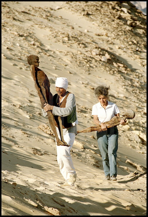 Site d'Ain Labakha. D'une dizaine de kilos seulement, ces momies peuvent être aisément transportées. L'historienne Françoise Dunand et le responsable égyptien de la mission archéologique les emportent vers le laboratoire, avec d'infinies précaution, pour un examen médical approfondi.