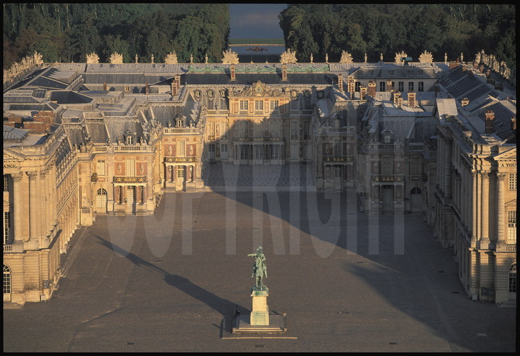 Vue en perspective des Cours : au fond de la Cour des Ministres, la statue équestre de Louis XIV, puis la Cour Royale et la Cour de Marbre. En arrière plan, le Tapis Vert, le Bassin d’Apollon et le Grand Canal.