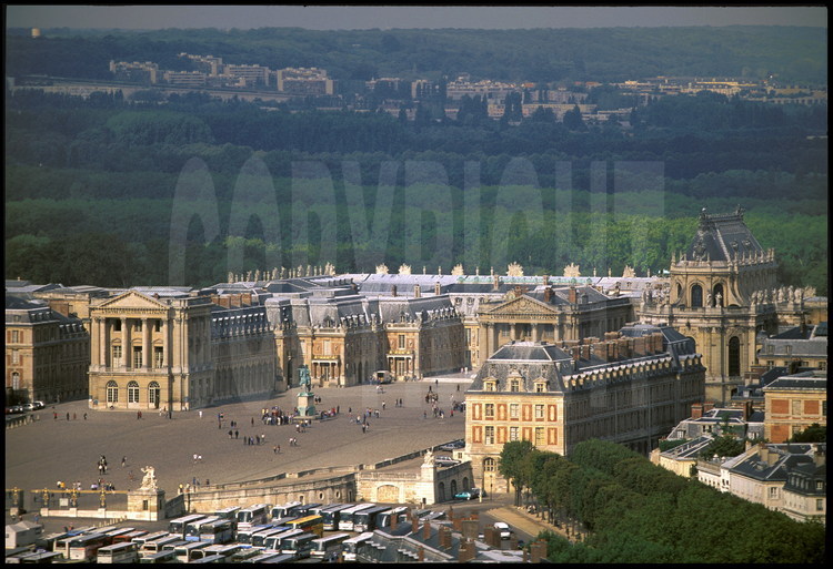 Vue générale du Château de Versailles, façade est. Au premier plan, la cour des Ministres. Au second plan, l’aile des ministres et la statue équestre de Louis XIV. En arrière plan, les jardins de Versailles et la ville de Saint Cyr-l’Ecole.