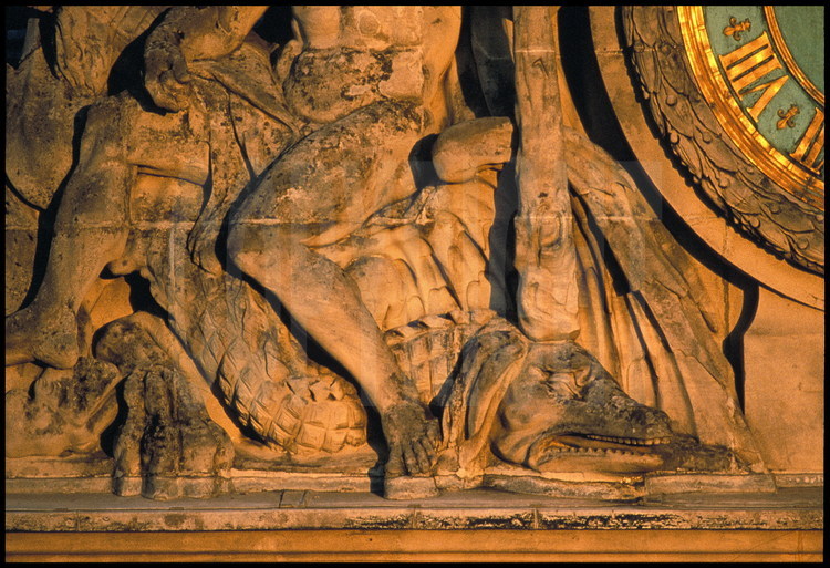 Éléments sculptés ornant la grande horloge du Château, réalisé par Girardon en 1679, d’après un dessin de Le Brun. Il représente Hercule au repos assis sur un dragon, symbolisant la victoire de la France sur ses ennemis.