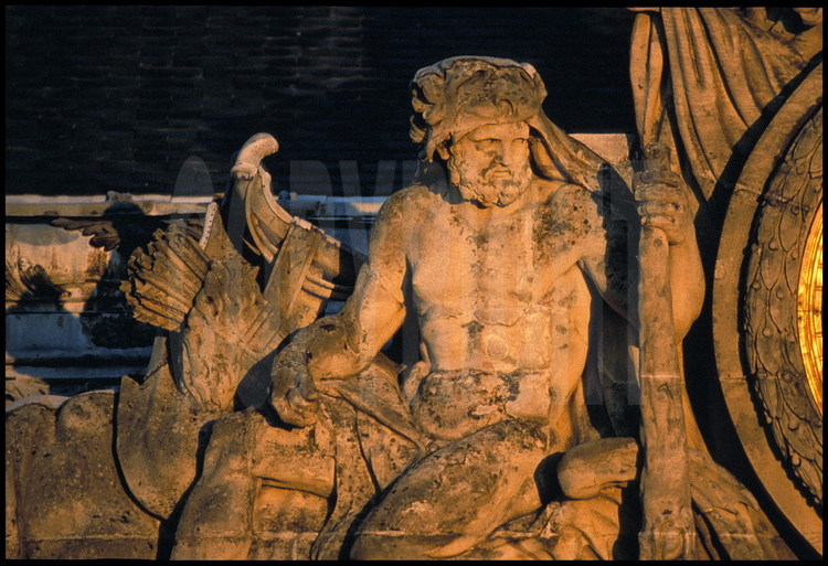 Éléments sculptés ornant la grande horloge du Château réalisé par Girardon en 1679, d’après un dessin de Le Brun. Il représente Hercule au repos assis sur un dragon, symbolisant la victoire de la France sur ses ennemis.