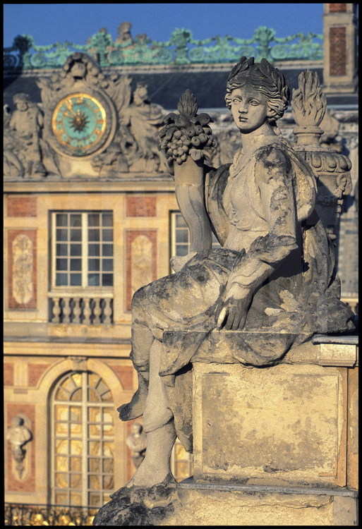 Statue représentant la Paix sur la balustrade nord de la Cour de Marbre. En arrière plan, la grande horloge du Château.