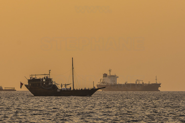 Oman. Felouque et pétrolier mouillant au large de Mascate. // Oman. Felucca and oil tanker docking off Muscat.