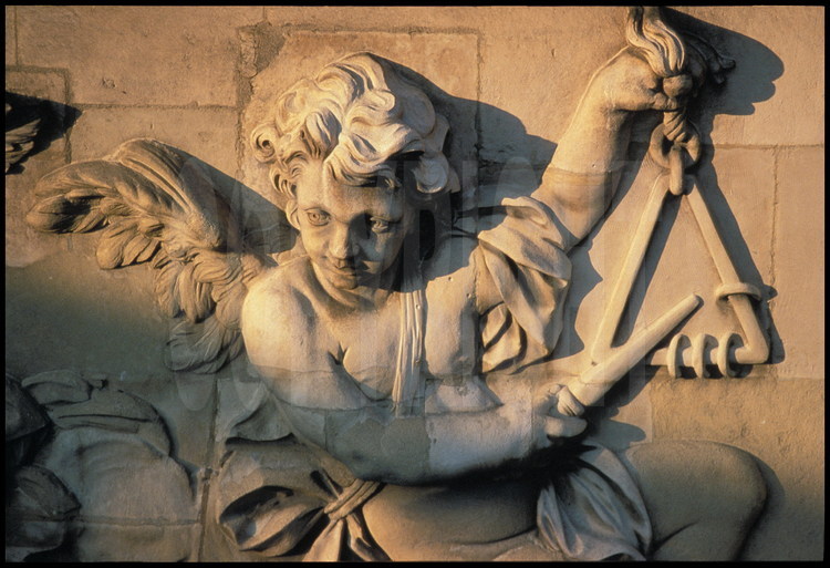 Sur la façade sud de la Chapelle, détail du décor sculpté sur les croisés de la tribune : ange jouant du triangle.