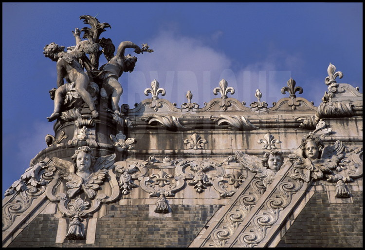 La Chapelle. Détail de la décoration du toit. A l’extrémité ouest du faîte (à gauche sur la photo) statue en plomb représentant trois enfants autour d’une palme.