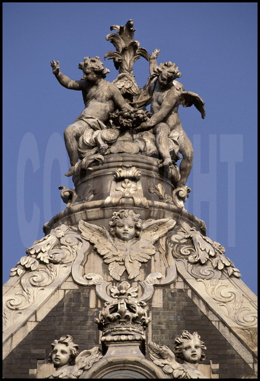La Chapelle. Détail de la décoration du toit. A l’extrémité ouest du faîte, statue en plomb représentant trois enfants autour d’une palme.