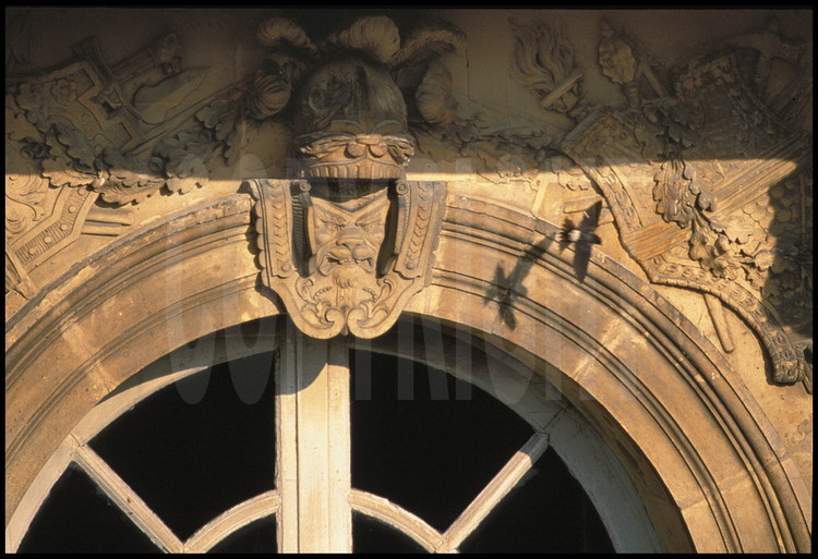 Détail ornemental aux arcades des fenêtres de la façade ouest du corps central : casque à plumes, cuirasse avec masque d’animal, trophée d’armes...et refuge d’un nid hirondelles.