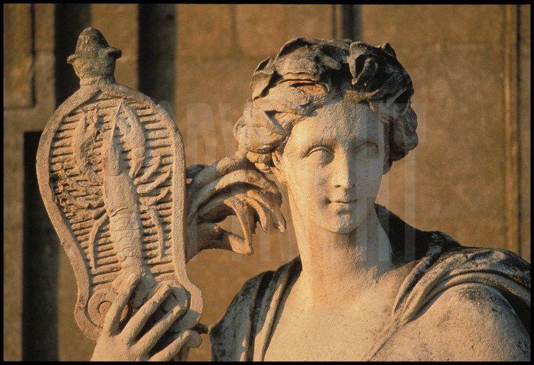 Ensemble statuaire représentant les douze mois de l’année : détail de la statue de Juin symbolisé par la divinité marine Galatée tenant un aviron orné d’une écrevisse (signe du Cancer). Corps central, façade sud.