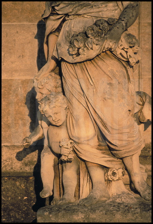 Ensemble statuaire représentant les douze mois de l’année: détail de la statue représentant le mois de Mai portant des fleurs et accompagnée de ses deux petits jumeaux ( signe des Gémeaux ). Corps central , façade ouest.