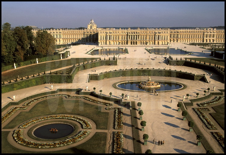 Vue générale de la façade ouest du Château de Versailles et de ses jardins à la française.