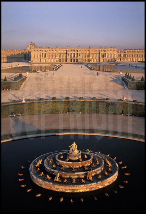 Vue générale de la façade ouest du Château de Versailles et de ses jardins à la française. Au premier plan, le Bassin de Latone, au second plan, les Parterres. Au fond, le corps central.