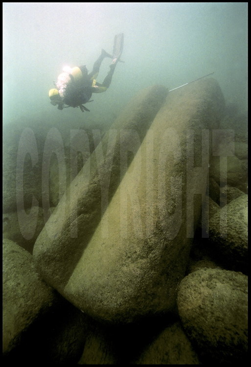 A diver on Jean-Yves Empereur’s team observes one of the sixty-ton blocks which surrounded the lighthouse entrance, estimated to be twelve meters high.