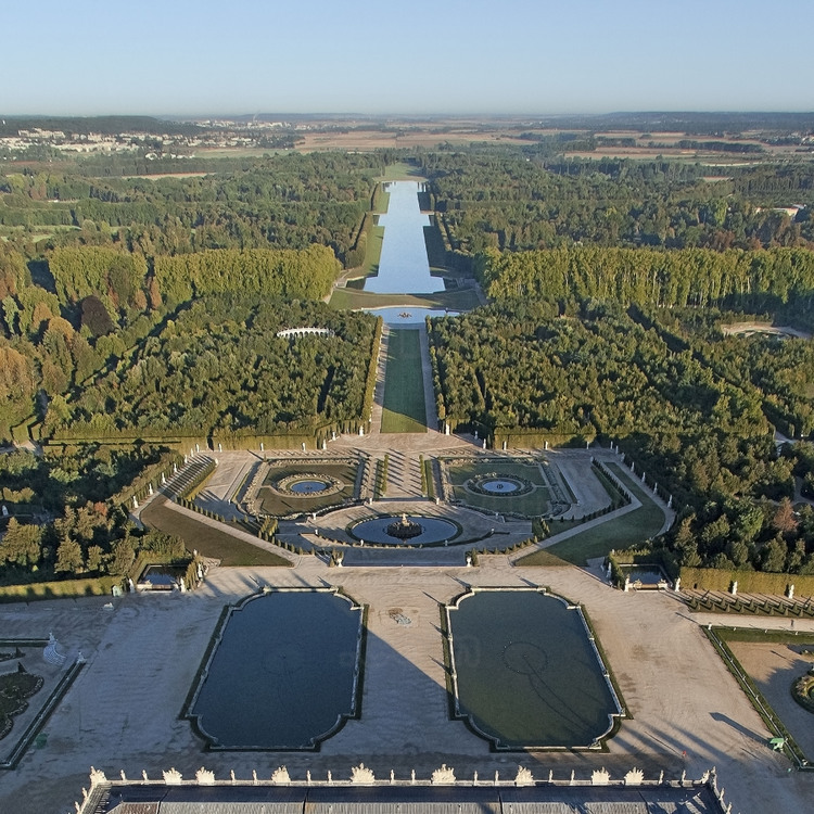 Vue d'ensemble de la grande perspective et de l'Axe du Soleil du parc de Versailles depuis l'est. Au premier plan, les Parterres d'eau.