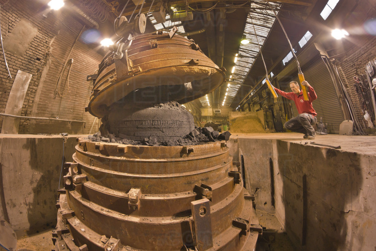 Asten, Netherlands. Royal Eijsbouts foundry, 24 September 2012. Ten days after casting, the big bell Marie (note G sharp, 6200 kg), in which the metal is still hot, is unmolded by Wim Hurkmans, head of the foundry workshop.