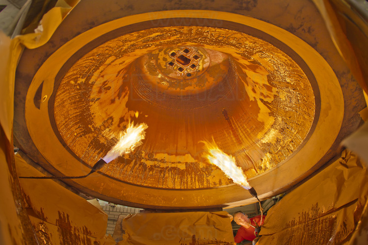 Asten, Pays Bas. Fonderie Royal Eijsbouts, 31 août 2012. Wim Hurkmans, responsable de l’atelier de fonderie, fait fondre la cire chaude à l'intérieur du moule de Marie (Sol dièse), un petit bourdon de 6,2 tonnes. Ses décorations, dont le 