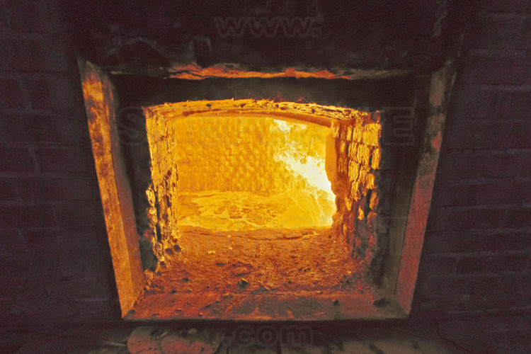 Villedieu les Poëles, fonderie Cornille Havard, France. 3 août 2012, jour de coulée de cloches. Dès 5 heures du matin, le four est allumé, puis alimenté en bois et en charbon. Vers 11 heures, les blocs de bronze et d'étain sont introduit à l'intérieur. Vers midi, le métal en fusion est à température (environ 1100 °C) et est prêt à être coulé dans le moule de la cloche, installé dans la fosse Diderot.