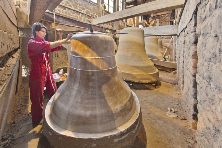 Villedieu les Poëles, Cornille Havard foundry, France. May 26, 2012. Specializing in decoration of bells, Virginie Bassetti, whose project for the bells of Notre Dame has been selected after a contest, put her first hand on the bell Étienne (note F, 1490 kg). Each decoration was cast in wax, by hand, and placed on the 